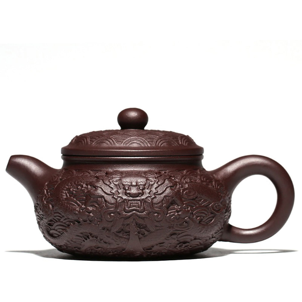 Close-up of the intricate embossed dragon design on the Yixing purple clay teapot.