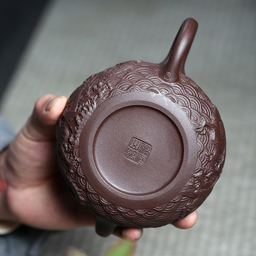 Close-up of the intricate embossed dragon design on the Yixing purple clay teapot.