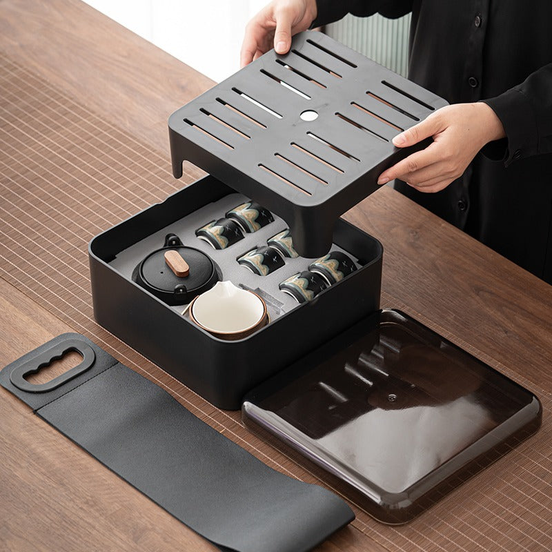 Close-up of the Japanese-style portable tea set with black ceramic finish and hand-drawn mountain and bird graffiti