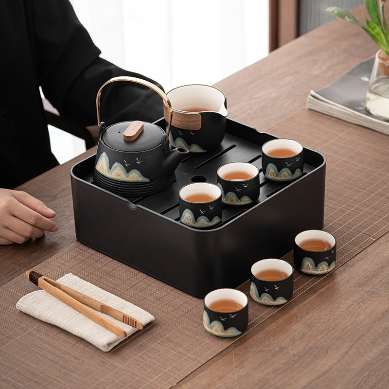 Portable tea set with tray and accessories laid out for tea brewing at home or outdoors