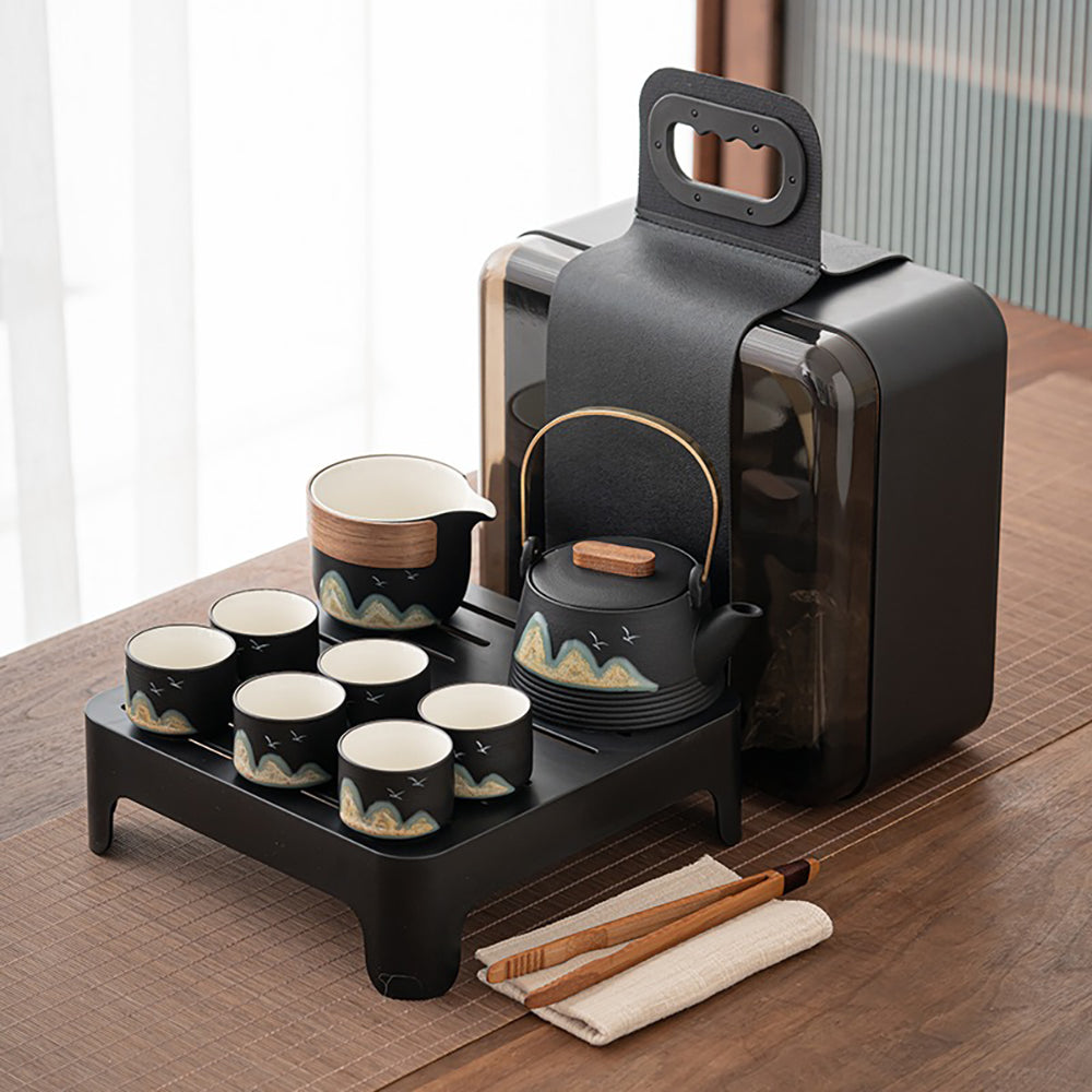 Close-up of the Japanese-style portable tea set with black ceramic finish and hand-drawn mountain and bird graffiti