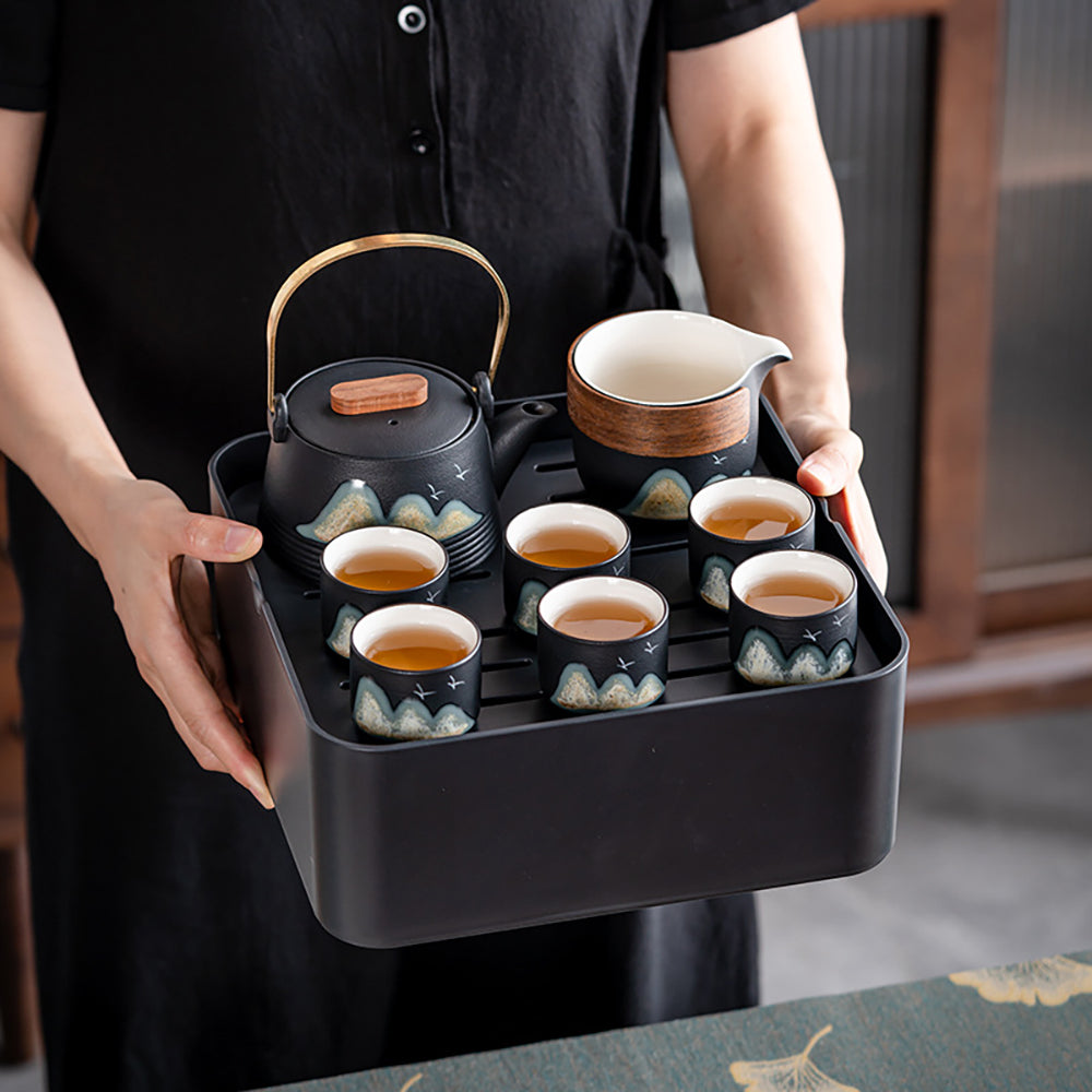 Portable tea set with tray and accessories laid out for tea brewing at home or outdoors
