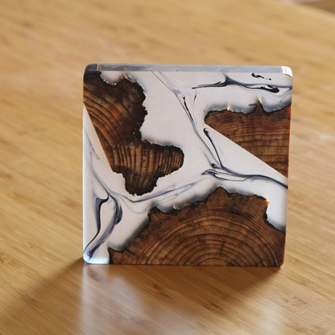 Close-up of epoxy coaster with tree design on wooden surface