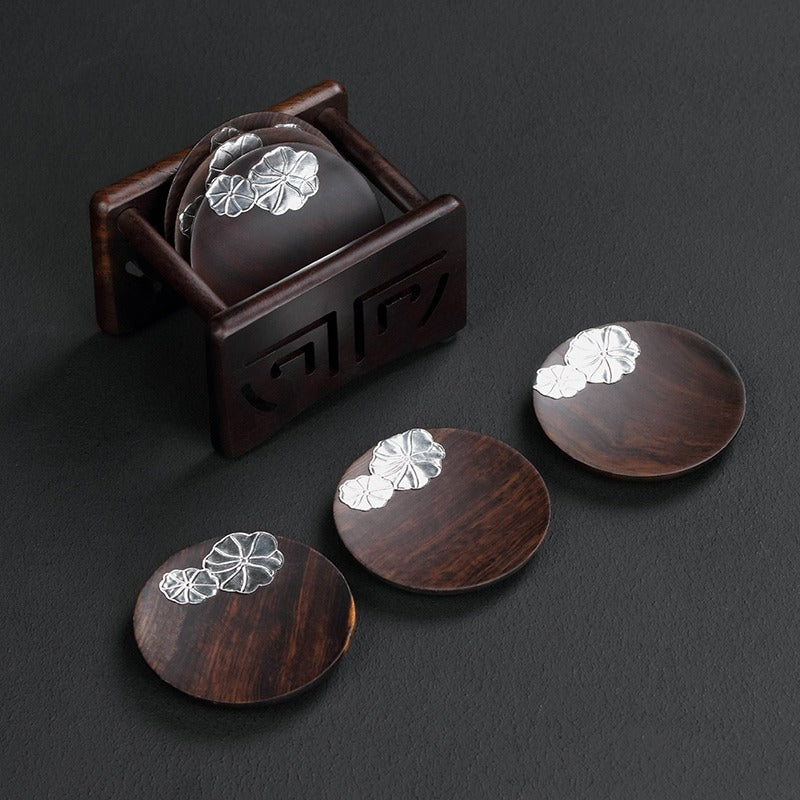 Ebony coaster set in use with wine glasses on a marble surface, highlighting durability and elegance