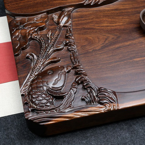 Top view of the wooden tray showcasing hand-carved goldfish and natural wood grain