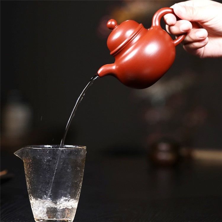 Angled view of the Yixing red clay big belly teapot, displaying its smooth lines and craftsmanship.
