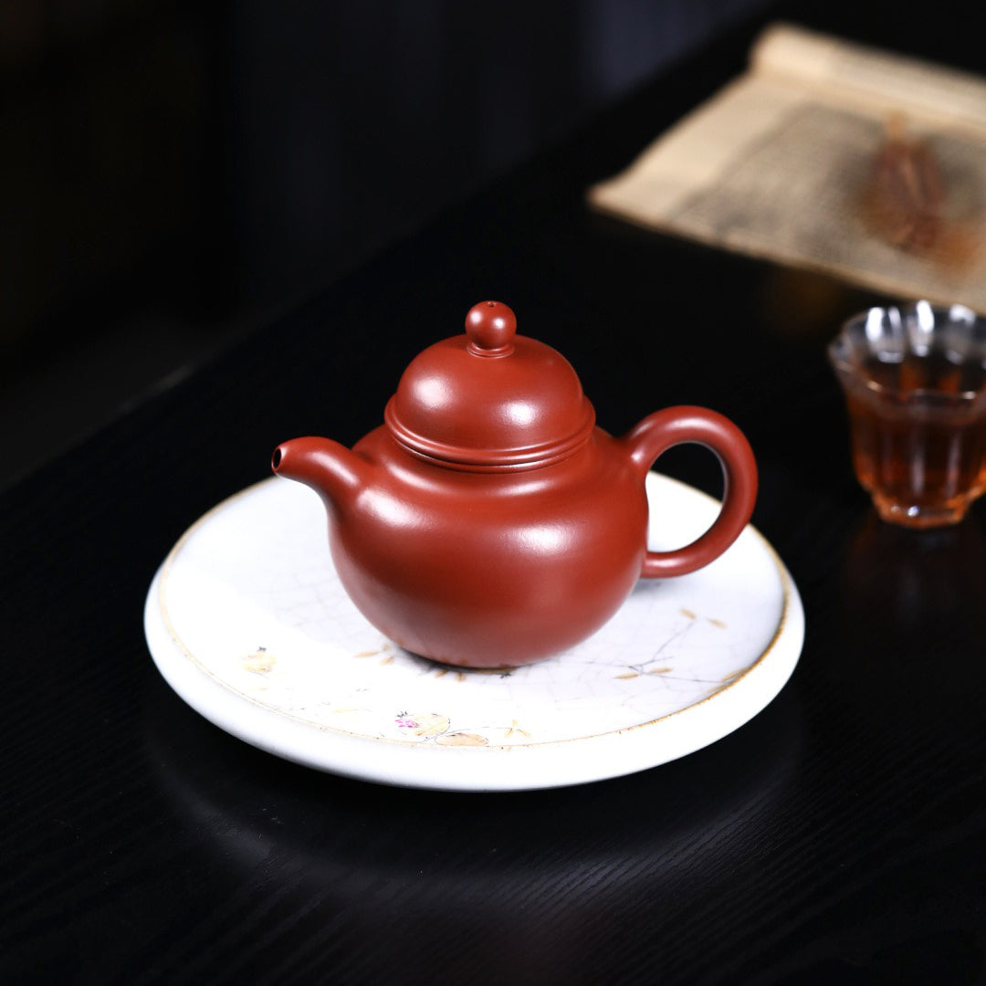 Angled view of the Yixing red clay big belly teapot, displaying its smooth lines and craftsmanship.