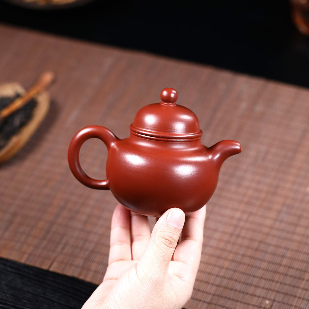Angled view of the Yixing red clay big belly teapot, displaying its smooth lines and craftsmanship.
