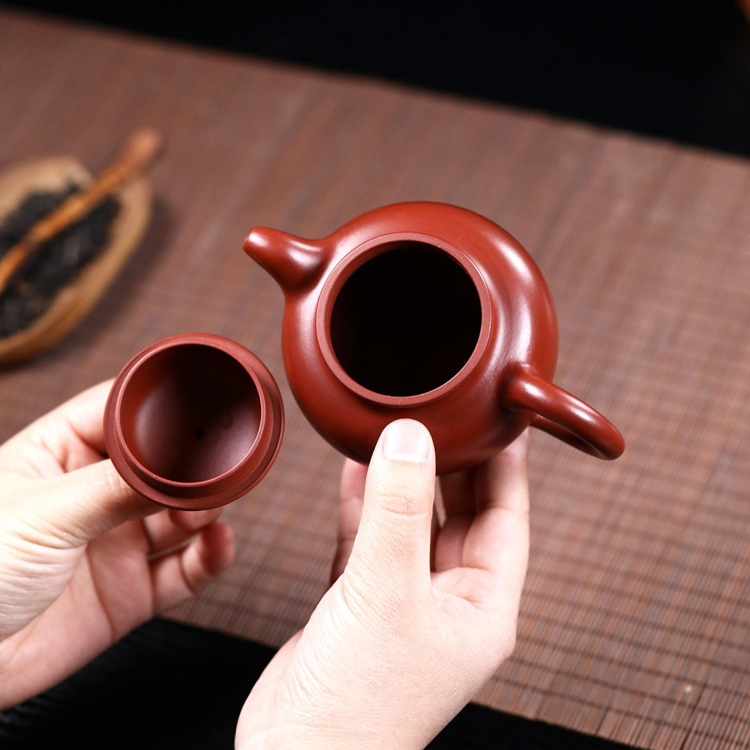 Yixing red clay teapot filled with freshly brewed Gongfu tea, highlighting its functionality and elegance.