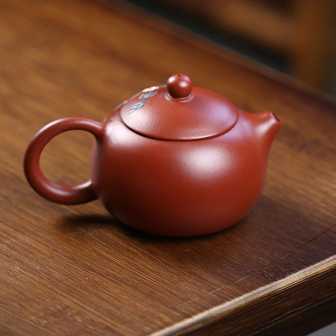 Exquisite peach blossom teapot showcasing intricate details from the side view.