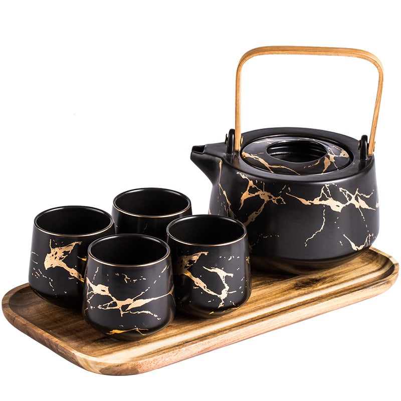 Close-up of the ceramic teapot with gold decals and detachable filter