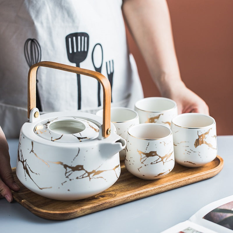 Tea set with cups, water pot, and wooden tray arranged for serving