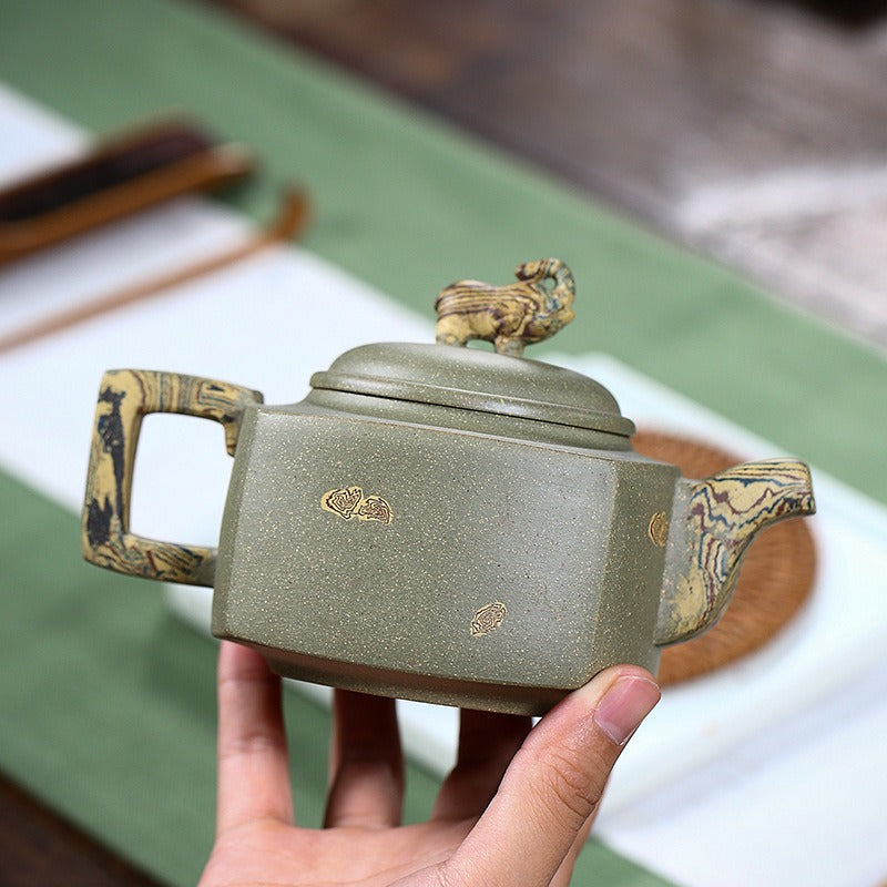 Side view of handmade purple clay teapot with smooth spout and square handle