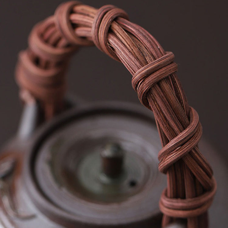Close-up of the Elegant Japanese Rattan Weaving Teapot highlighting its intricate floral patterns and rattan handle.