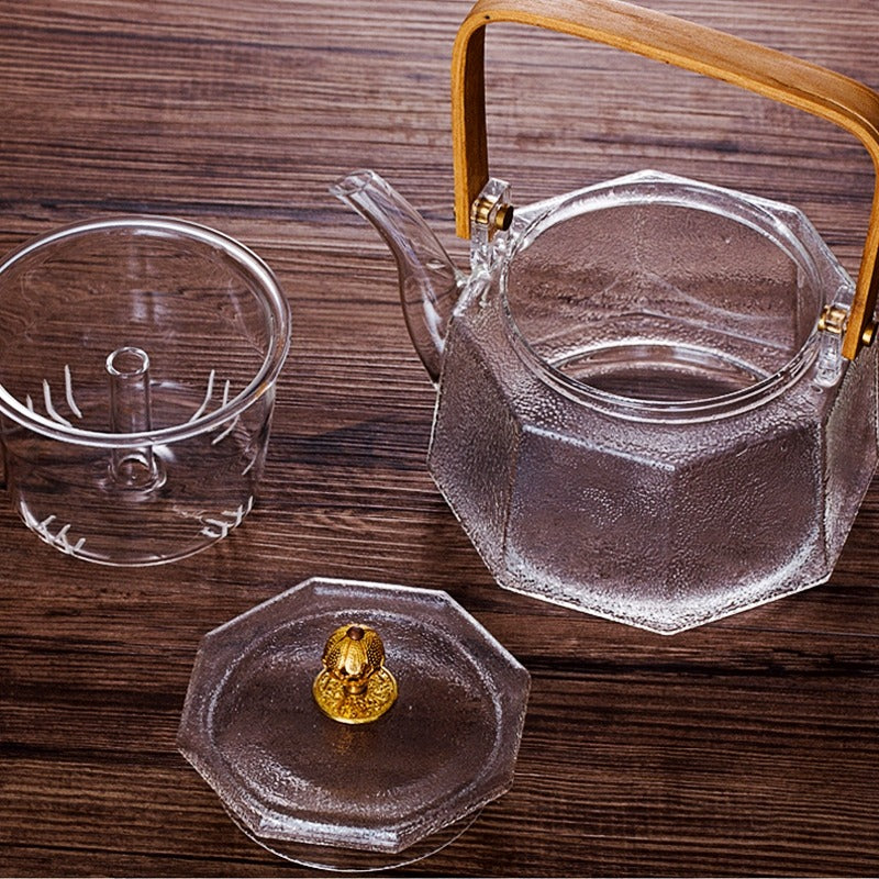 Elegant Japanese steam glass teapot showcasing blooming tea leaves.