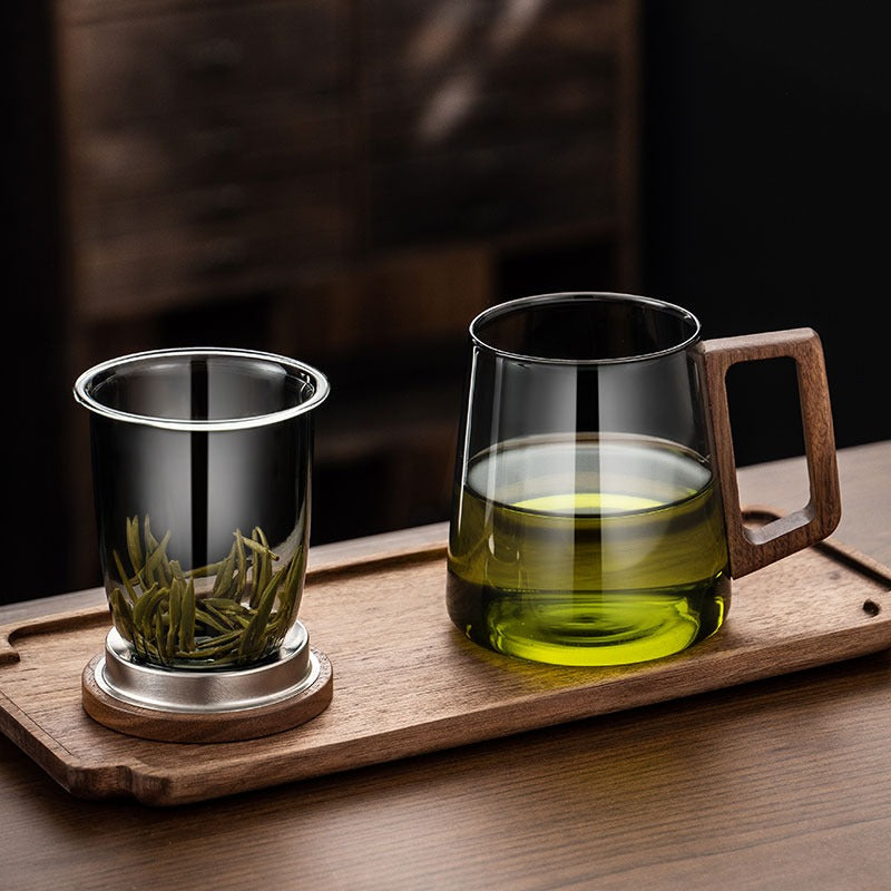 Close-up of a clear glass tea cup with infuser and loose leaf tea inside