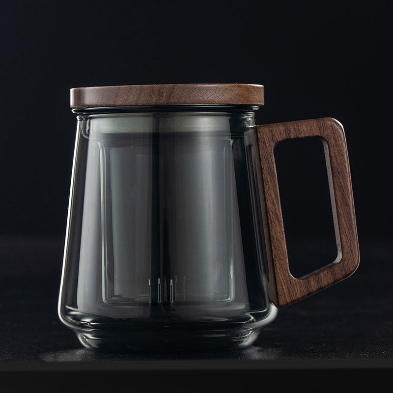 Close-up of a clear glass tea cup with infuser and loose leaf tea inside