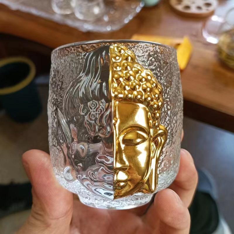 Angled view of the Buddha-inspired glass tea cup showing its elegant curves and clear texture