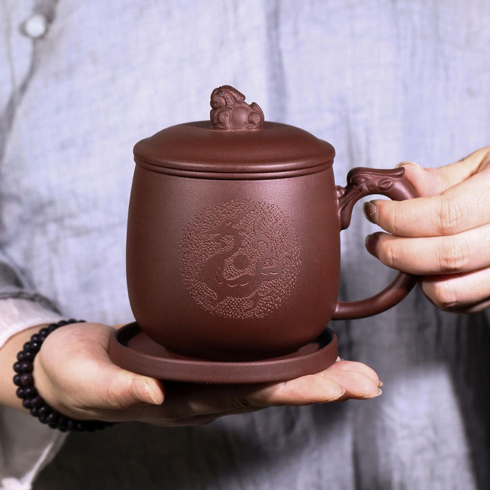 Close-up of purple clay dragon tea cup with infuser, showing detailed dragon handle and lid