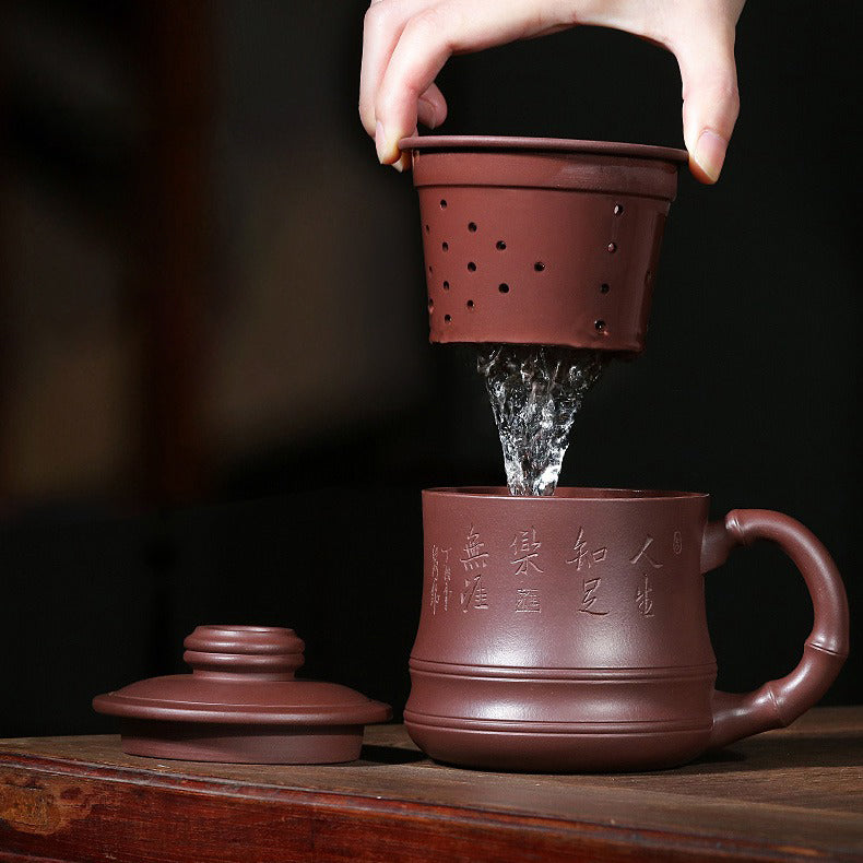 Close-up of purple clay bamboo teacup with infuser showing intricate carvings