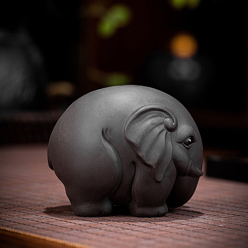 Tea lover arranging a Yixing clay elephant tea pet for tea ceremony