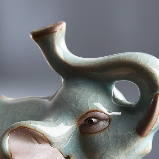 Tea lover pouring leftover tea onto the Ru Yao Elephant Tea Pet during a traditional tea ceremony