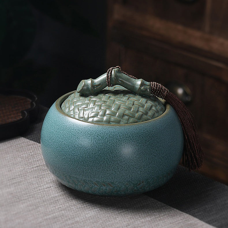 An open ceramic tea caddy filled with loose leaf tea, demonstrating its capacity and airtight seal.