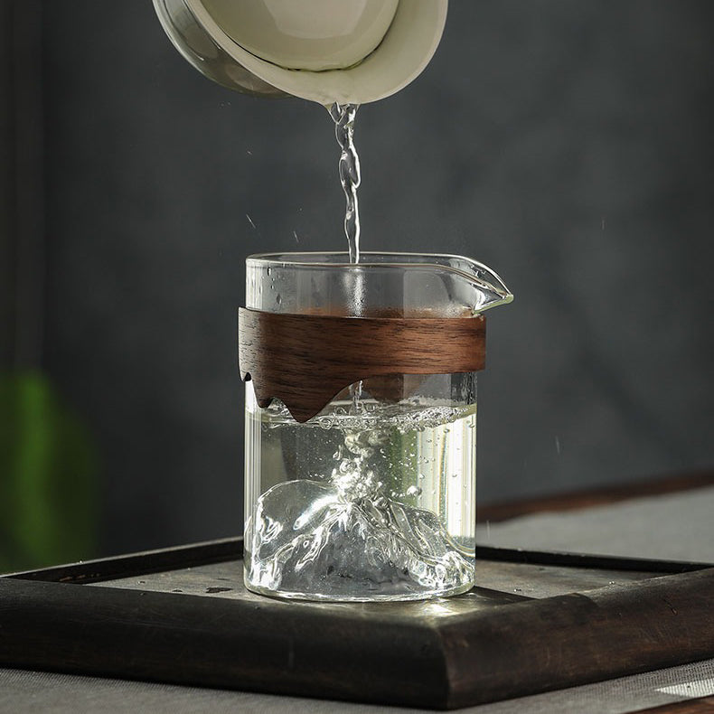 Stylish glass tea cup with bamboo handle displayed on a table