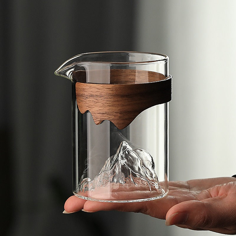 Stylish glass tea cup with bamboo handle displayed on a table