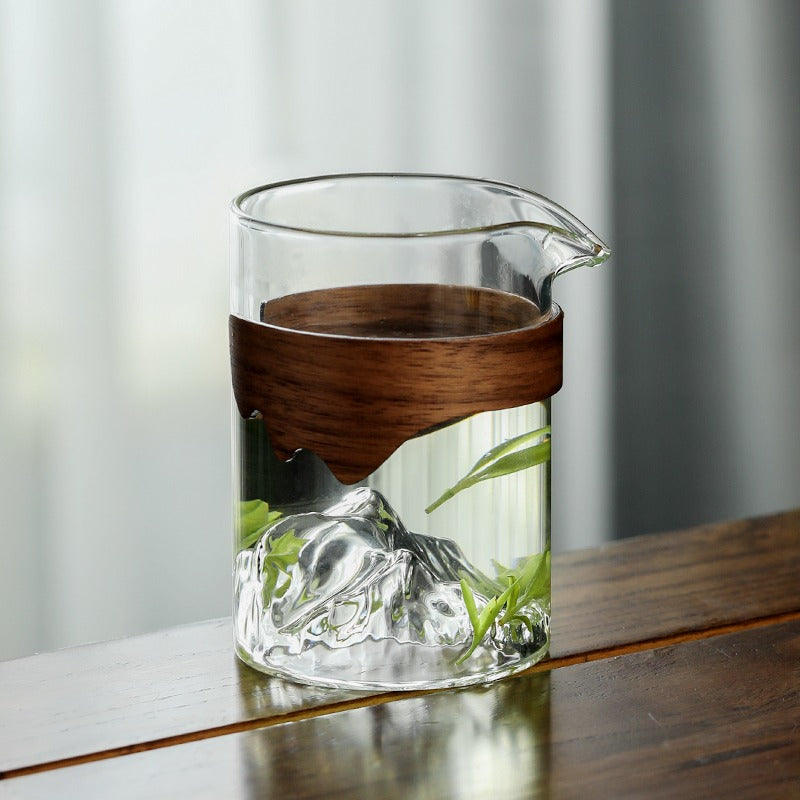Stylish glass tea cup with bamboo handle displayed on a table