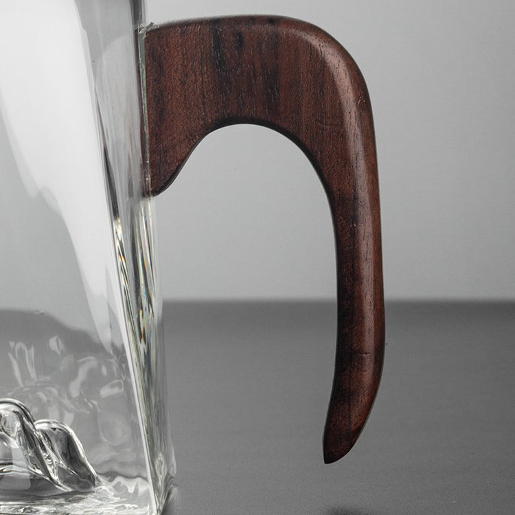 Side angle of the glass cup showing its spacious interior and sturdy wooden handle
