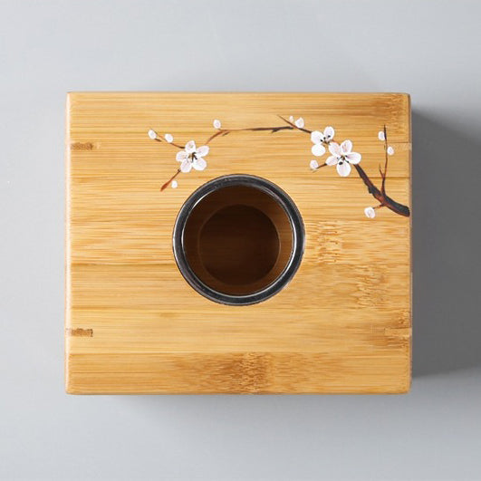 Tea warmer in use, maintaining the temperature of a steaming cup of tea