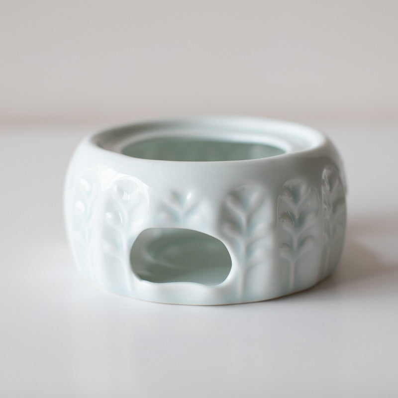 Lifestyle shot of ceramic tea warmer on a wooden tray with black tea