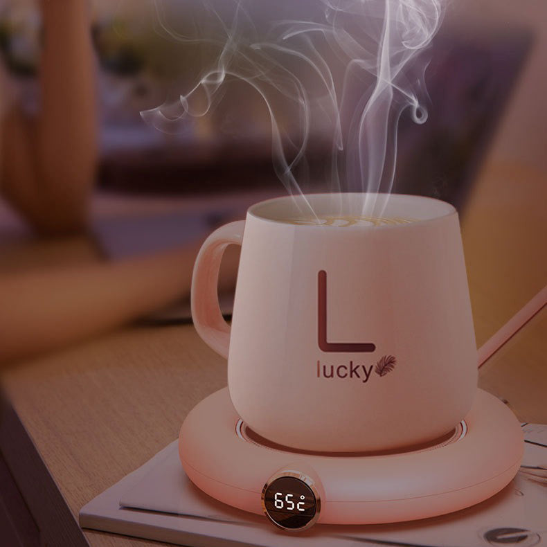 Ceramic tea warmer with a steaming cup of tea, highlighting its heat retention feature