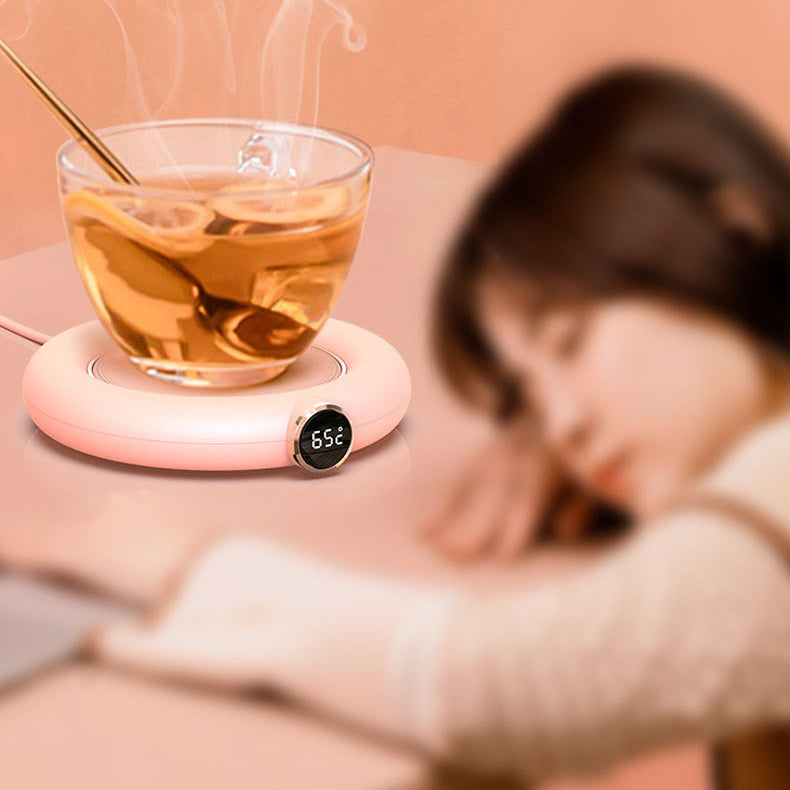 Close-up of ceramic USB teapot warmer with tea pot on top, stylish and modern design