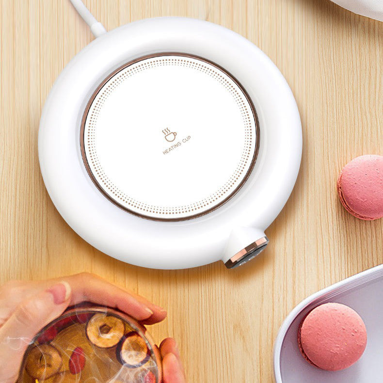 Close-up of ceramic USB teapot warmer with tea pot on top, stylish and modern design