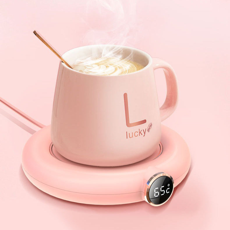 Ceramic tea warmer with a steaming cup of tea, highlighting its heat retention feature