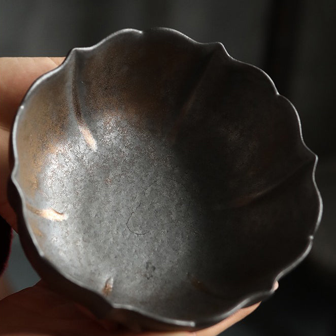 Lotus shaped ceramic tea washer in use during a traditional tea ceremony.