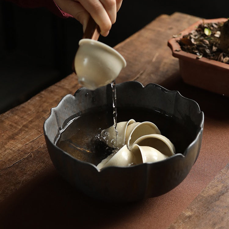 Close-up view of boiling water being poured into the tea washer for disinfecting tea cups.