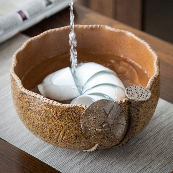 Close-up of the Artisan Coarse Pottery Lotus Tea Washer filled with boiling water