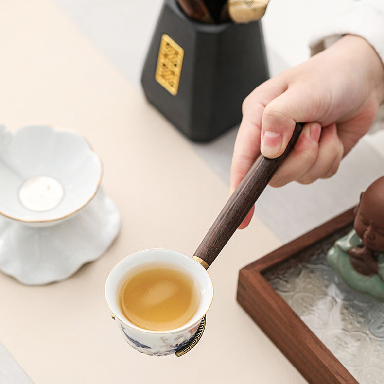 Ebony tea utensils set displayed on a traditional tea table, showcasing the black ceramic holder.