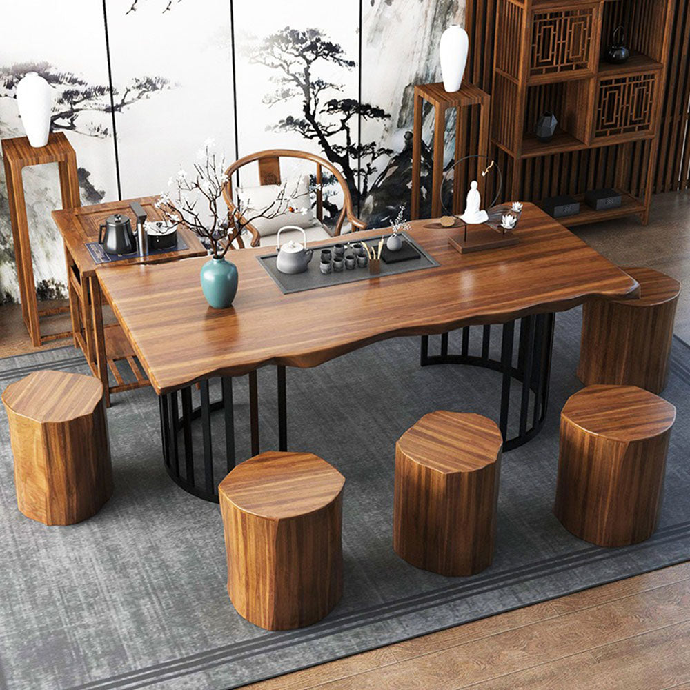 Front view of rustic wooden tea table with stools in a cozy living room setting.