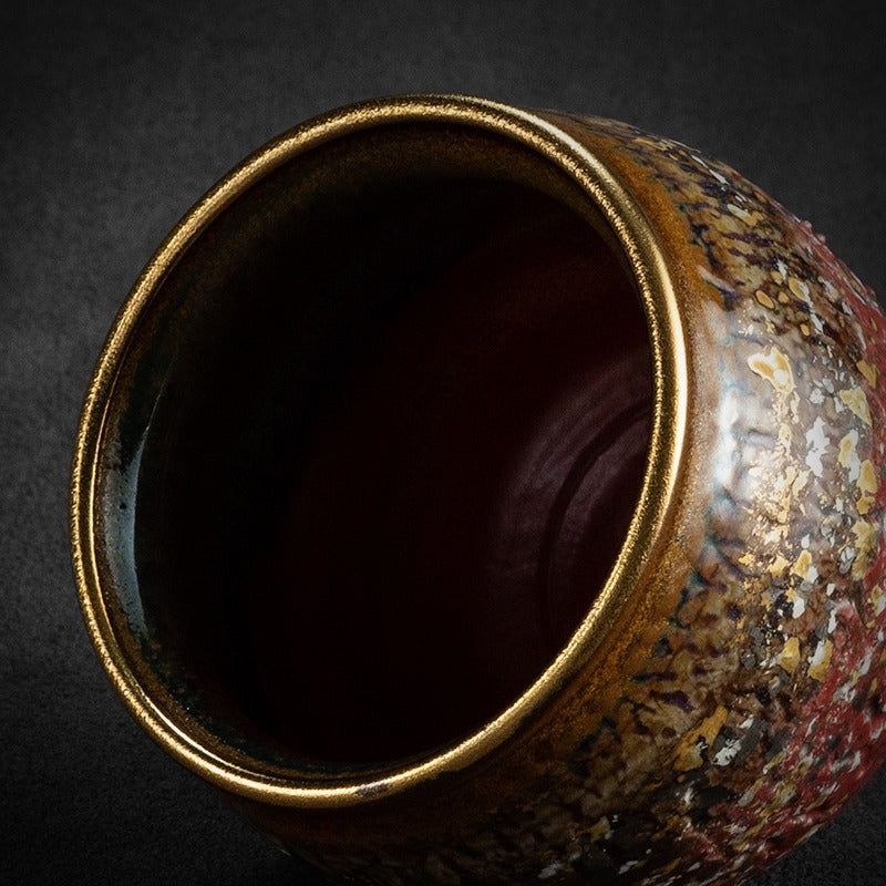 Tea cup set on a wooden table, highlighting its luxurious gold finish.