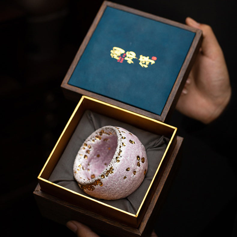 Close-up view of the pink glazed tea cup, highlighting the flowing-gold glaze and retro style.