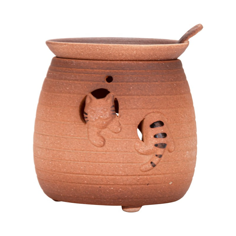 Cute cat pottery tea warmer in use with tea