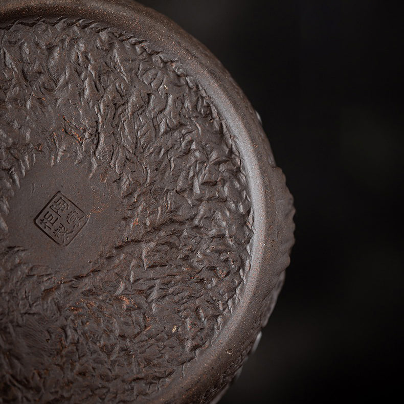Close-up of vintage style plum blossom rock clay teapot warmer showing textured surface