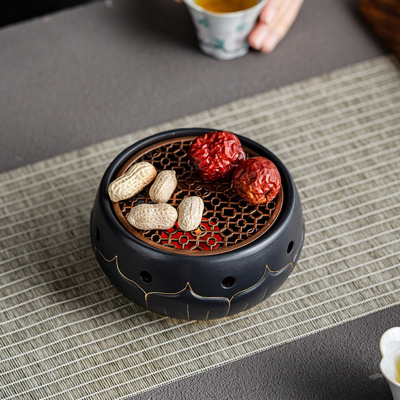 Close-up of black ceramic lotus teapot warmer with gold accents