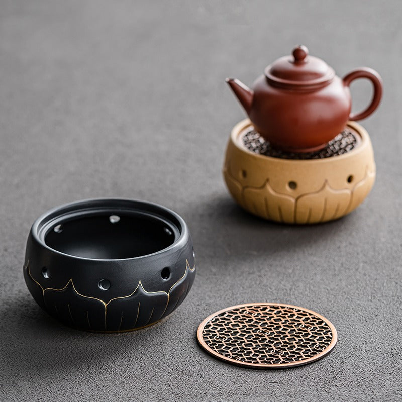 Close-up of black ceramic lotus teapot warmer with gold accents