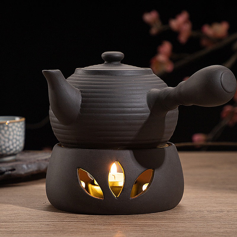 Elegant clay teapot warmer in use, keeping tea warm on a dining table.
