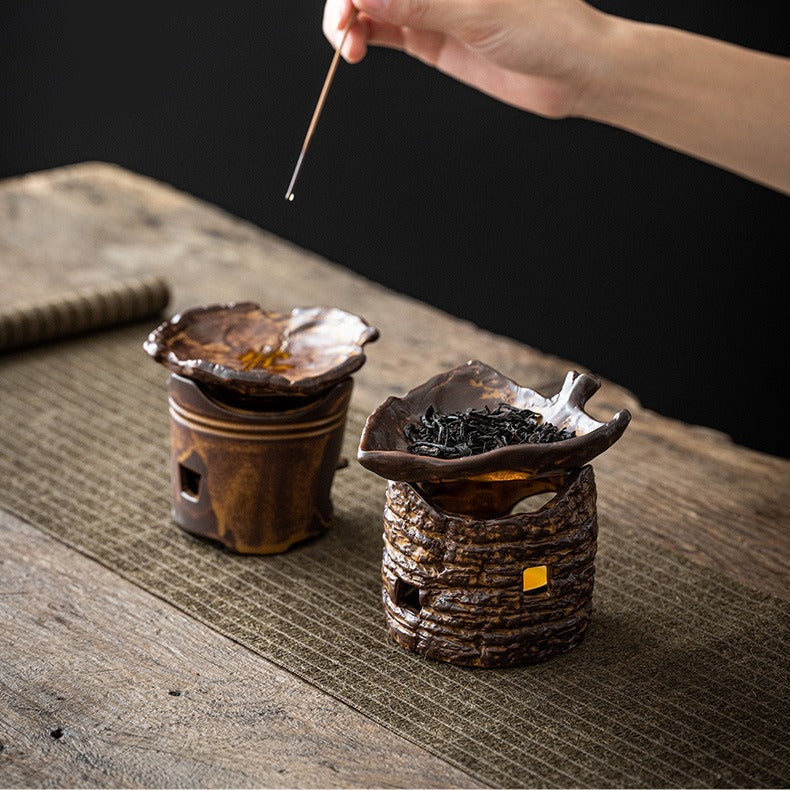 Close-up of the handmade tea warmer with a tea pot atop, demonstrating its practical use.